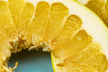 Round pomelo slices on a light blue background. Citrus yellow fruit.
