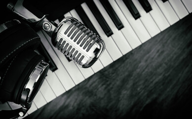 Headphones and microphone on the piano keyboard. Recording studio concept.