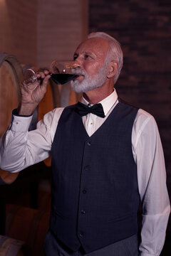 Senior man tasting wine in cellar