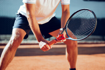 Tennis player standing in ready position on tennis court