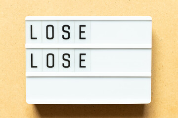 Lightbox with word lose lose on wood background