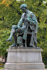 Fototapeta na wymiar Statue of chemist Carl Wilhelm Scheele under the rain in Humlegarden park in Stockholm, Sweden