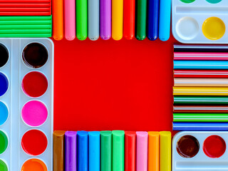 Office supplies on a red background. Various school supplies on a bright red background