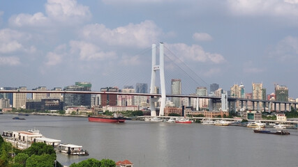 Shanghai: Nanpu-Brücke. Schiffe fahren auf dem Fluss. Wohngebäude und Himmel. China. Asien