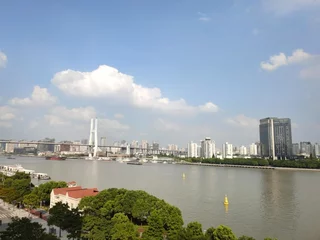 Fotobehang Nanpubrug Shanghai: Nanpu-brug. Schepen varen op de rivier. Residentiële gebouwen en lucht. China. Azië