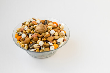 Mixed nuts in glass bowl on white surface with copy space,close up taken