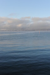 Vapour of haze over Vättern lake in Gränna in Sweden on a sunny winter day with blue sky, clear air and water