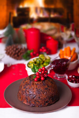 Traditional Christmas pudding with holly on top on a Christmas dinner.