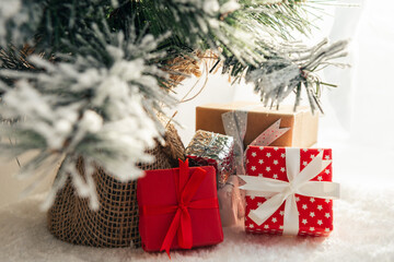 Christmas gifts under christmas tree on white carpet