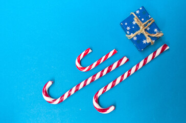 Gift box with christmas candy cane, place for text on blue background