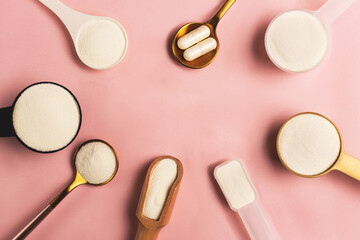 Frame made with collagen powder and pills spoons on pink background. Extra protein intake. Natural beauty and health supplement for skin, bones, joints and gut. Plant or fish based. Flatlay, top view.
