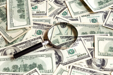 Magnifier on dollar banknotes background. 100 USA dollar bills with lens. Financial analysis. Investments. Cash and savings. American money.  Business, finance concept. Copy space.