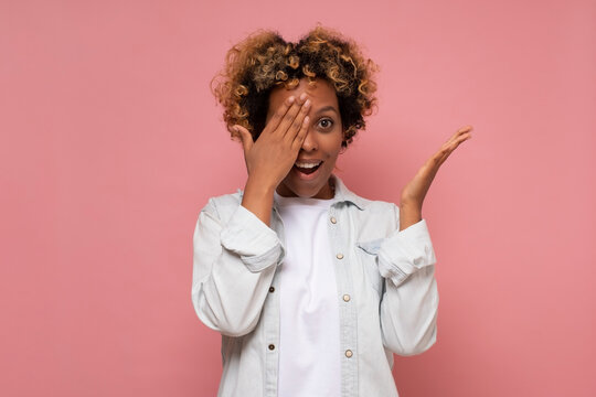 Attractive African American Woman Covering Eyes With Palms And Peeking With One Eye, Smiling