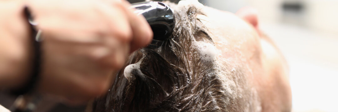 Master washes client's hair with shampoo in hairdressing salon. The list of services in the beauty salon concept