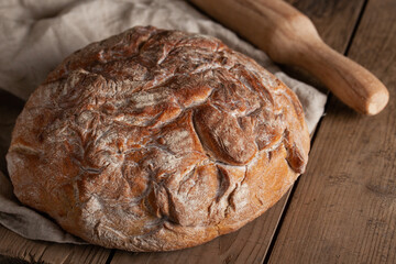 Fresh crusty homemade bread on wooden table.