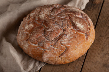Fresh crusty homemade bread on wooden table.