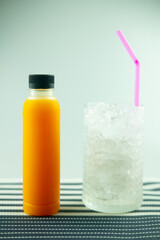 One fresh orange juice in bottle and ice cubes