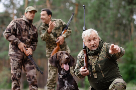 Family Man And Sons Hunting With Pointer Dog.