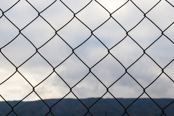 Metal fence background, real fence close-up and texture on sky background