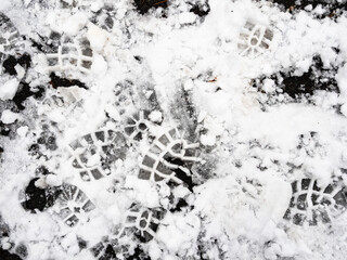 above view of textured footprints in the first snow on surface of outdoor playground close up on...
