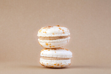 
French dessert macaroni with vanilla and white chocolate ganache on a brown background