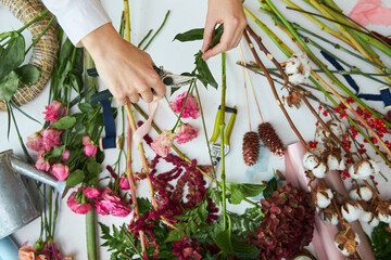A female florist is engaged in the manufacture of a bouquet. Hands close-up.