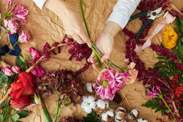 Flat lay composition florist creates a bouquet on craft paper