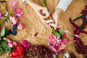 Fototapeta na wymiar Flat lay composition florist creates a bouquet on craft paper
