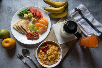 Breakfast platter arranged with rich protein content of cornflakes, fruits, milk, bananas and saute vegetables