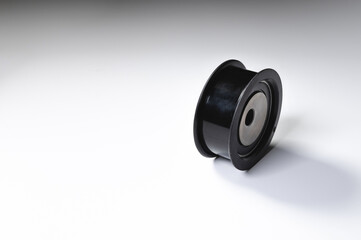 New timing belt tensioner roller close-up macro shot on gray background