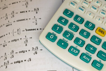 math book with calculations to solve and scientific calculator