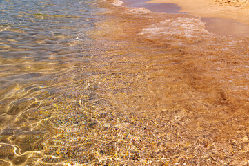 Calm morning sea beach shore with small rocks and waves