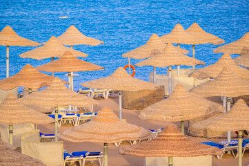 Relaxing at paradise beach - Chaise lounge and parasols - travel destination Hurghada, Egypt