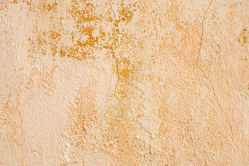 Grunge background of cracked peeling walls with peeled putty in beige tones