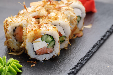 Sushi roll with tuna shavings on plate close up