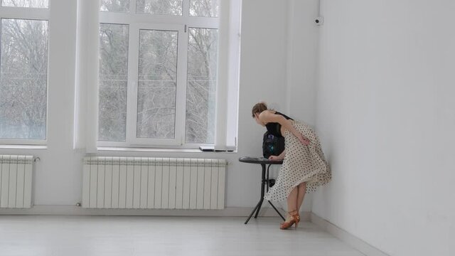 Young beautiful girl dancing ballroom dancing. A professional ballroom dancer is engaged in a large white hall.