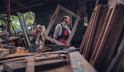 Carpenter man cutting wood with saw. craftsman working workshop factory industry.  Capenter worker with mask protection.