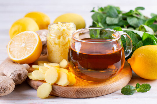 A glass cup of fresh herbal tea with lemon, honey, ginger and mint leaves. Fall immune system booster