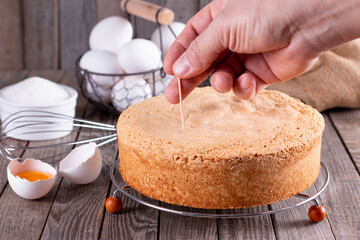 Check a sponge cake for doneness by using the toothpick test.