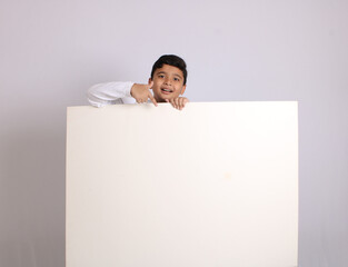 Young Indian schoolboy showing blank copy space.