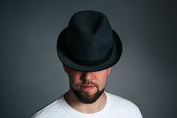 Handsome Bearded Man in Hat. On a grey background