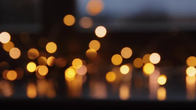 holidays and celebration concept - blurred christmas lights on window sill