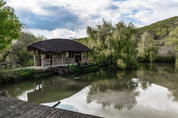 Naklejka premium Wooden hut on the edge of the pond