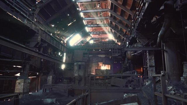 Large hangar or workshop of old rusty industrial metallurgical plant, atmosphere of destruction and post-apocalypse.