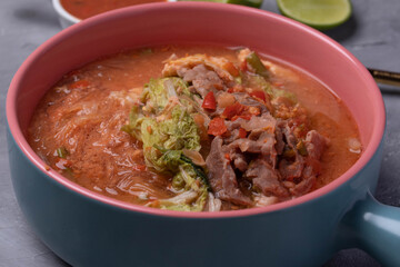 Suki, pork and vegetables in ceramic cup, gray background