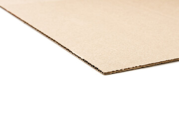 One sheet of corrugated cardboard isolated on a white background. The subject lies in the plane diagonally and casts a small soft shadow.