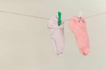 socks, dry after washing, hanging on a clothesline with clothespins on a light background