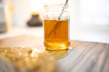 Honey jar and a slice of bread with peanut butter on wooden table