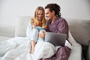 Loving young couple having breakfast in bed