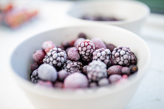 Bowl of dark berries on a white table